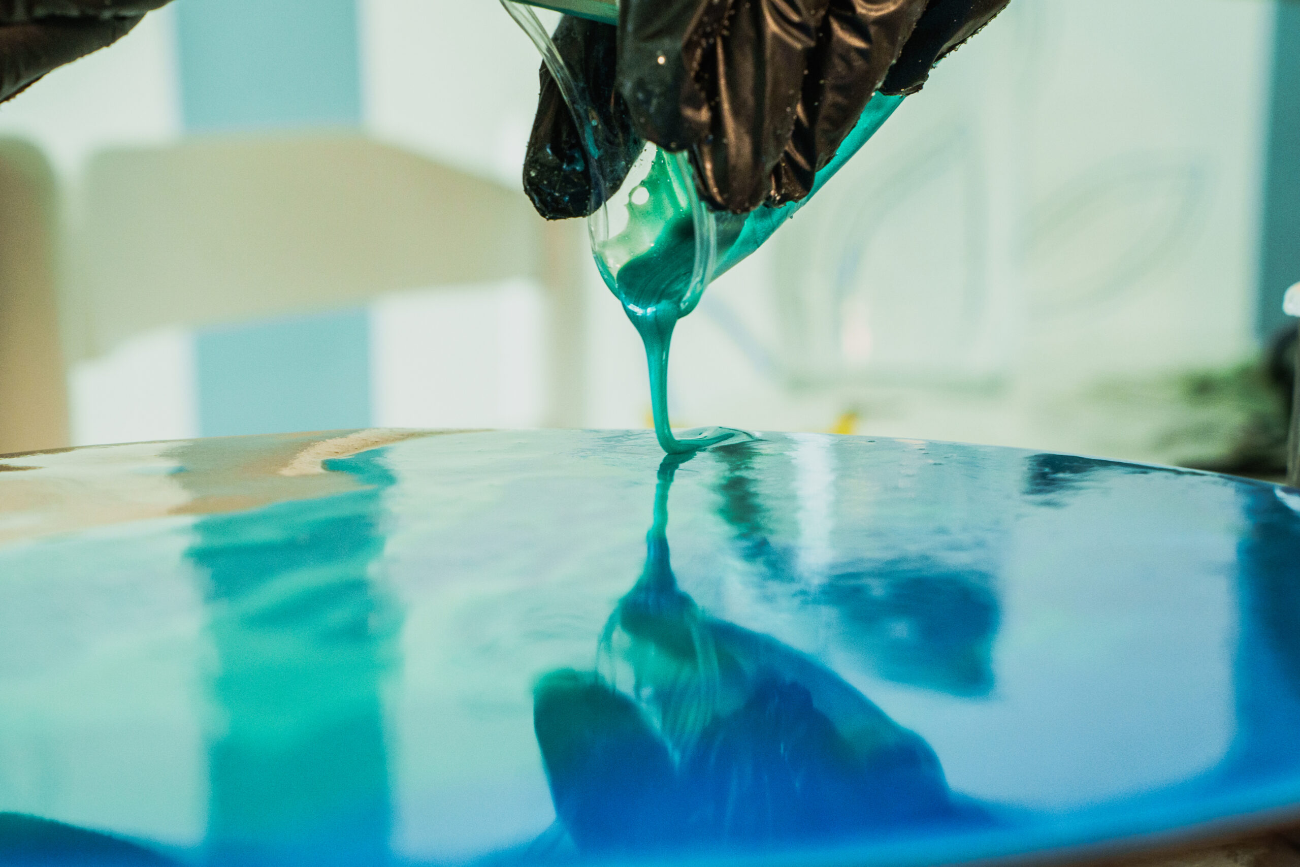 Creating epoxy resin art of ocean waves on a round wooden base. Expoxy Resin